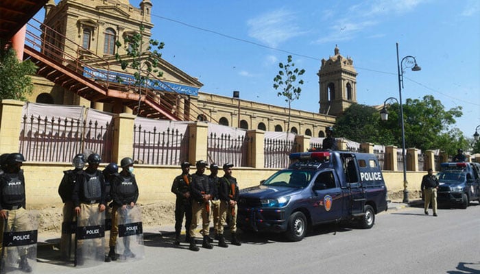 Policemen stand guard outside a polling station during the nationwide general elections in Karachi on February 8, 2024. — AFP