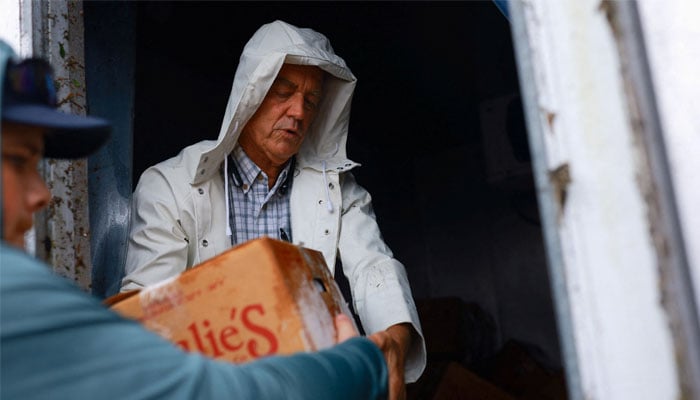 A man collects food from his business that he lost after the landfall of Hurricane Milton, in Lakewood Park, near Fort Pierce, in St Lucie County, Florida, US, on October 11, 2024. – Reuters