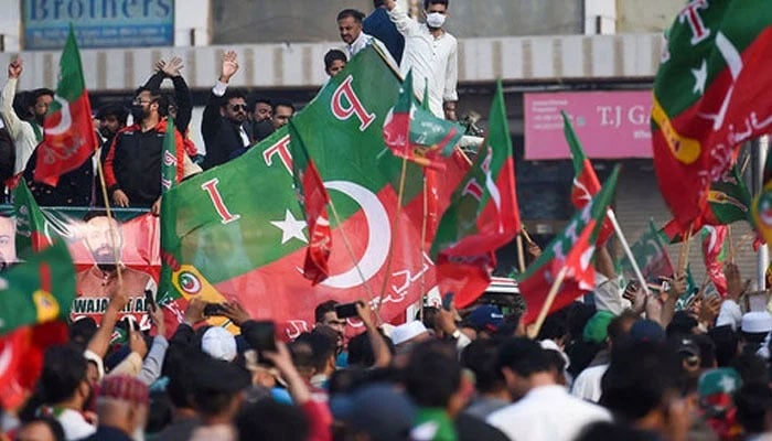 Supporters of the PTI hold flags in a rally on January 28, 2024. — AFP