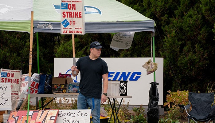 Boeing worker Riley Nelson holds a sign at a picket line near the entrance to a Boeing production facility in Renton, Washington, US on October 11, 2024. — Reuters