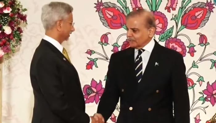 Prime Minister Shehbaz Sharif (right) shake hands with Indian foreign minister Subrahmanyam Jaishankar at dinner for SCO leaders. — Screengrab via Geo News