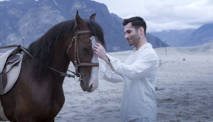 Ahmad Memon poses with a horse during a photoshoot in this undated photo.— Reporter