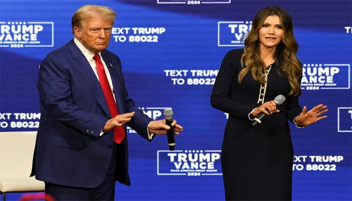 Republican presidential nominee former U.S. President Donald Trump and South Dakota Governor Kristi Noem dance during a town hall campaign event in Oaks, Pennsylvania, US, October 14, 2024. —Reuters