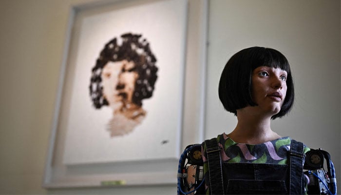 Humanoid AI robot Ai-Da poses in front of a painting she made during the press preview of the London Design Biennale 2023 at Somerset House, central London, on June 1, 2023. — AFP