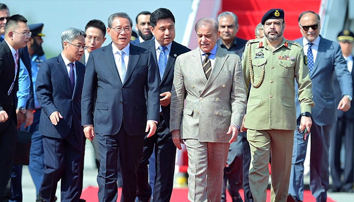 Chinas Premier Li Qiang speaking with Prime Minister Shehbaz Sharif upon his arrival at the Chaklala military air base in Islamabad on October 13, 2024. — AFP