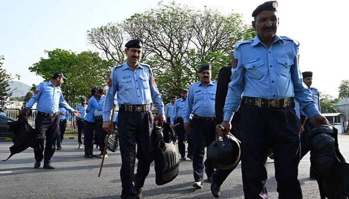 Police officers reach outside the Parliament House building in Islamabad on April 9, 2022. — AFP