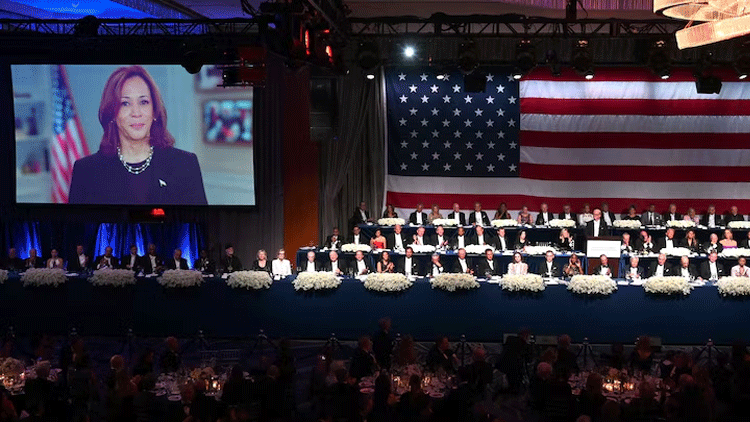 An video of US Vice President Kamala Harris is playing on screen as former US President and Republican presidential candidate Donald Trump with his wife Melania Trump and other dignitaries attend the 79th Annual Alfred E Smith Memorial Foundation Dinner at the Hilton Midtown in New York on October 17, 2024. — AFP