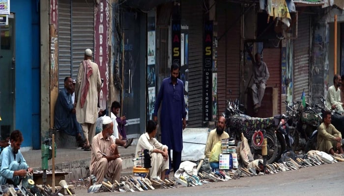 Labourers sitting along a roadside during a hot weather at Burns Road area in Karachi on October 17, 2024. —PPI