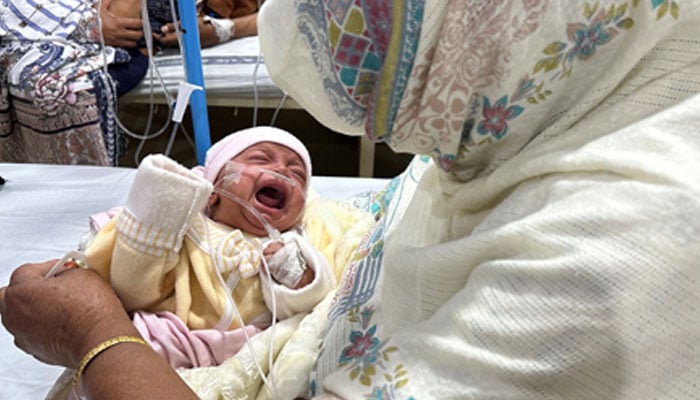 A representational image showing an infant being taken care of by a caregiver in a hospital. — Reuters/File