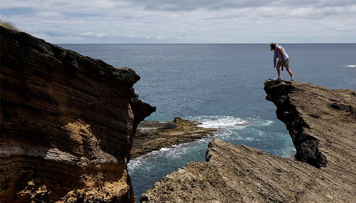 A man looks over a cliff edge on the Vila Franca Islet, the exposed remains of a volcanic cone and a protected nature reserve, off Sao Miguel Island in the Azores archipelago, Portugal July 2, 2024. — Reuters