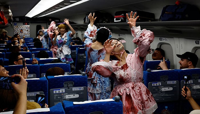 Para pemain berpakaian zombie mempraktikkan penampilan mereka sebelum menaiki kereta peluru Zombie Shinkansen menuju Osaka dari Tokyo, terinspirasi oleh film Korea Selatan Train to Busan, menjelang musim Halloween, di Tokyo, Jepang 19 Oktober 2024. — Reuters