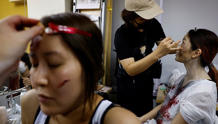 Performers have zombie make-up before boarding a Zombie Shinkansen bullet train bound for Osaka from Tokyo, inspired by the South Korean movie Train to Busan, ahead of the Halloween season, in Tokyo Japan October 19, 2024. — Reuters