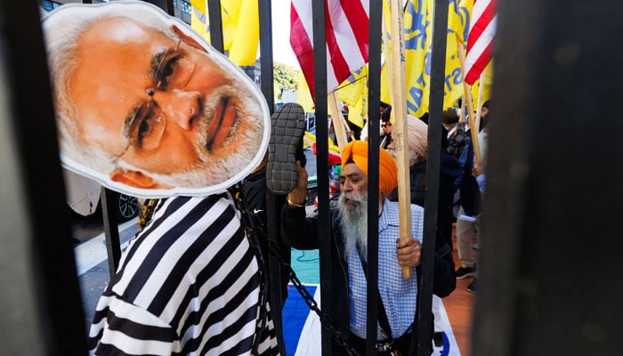 Sikh separatist activists with the Khalistan movement deface a placard and mannequin of Indian Prime Minister Narendra Modi as they protest outside the Consulate General of India in Toronto, Canada, October 18, 2024. — AFP