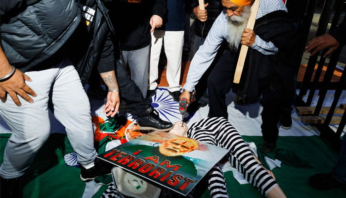 Sikh separatist activists with the Khalistan movement deface a placard and mannequin of Indian Prime Minister Narendra Modi as they protest outside the Consulate General of India in Toronto, Canada, October 18, 2024. — AFP