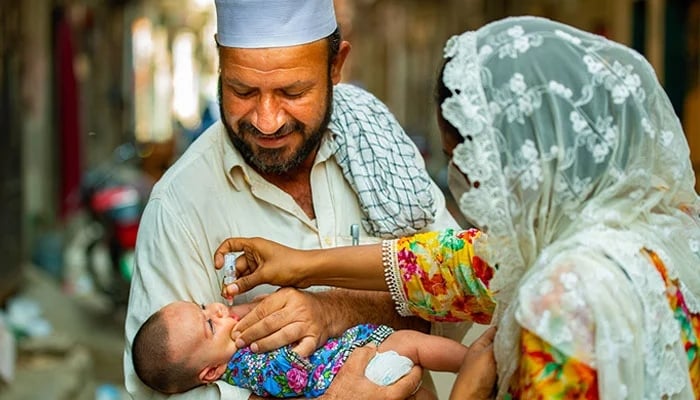 A baby is vaccinated in Maraghzar Colony in Lahore. — WHO/File