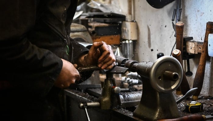 Ruari Black, the last traditional bagpipe-makers who make everything by hand from start to finish, makes a bagpipe chanter in the workshop of Kilberry Bagpipes in Edinburgh, on October 7, 2024. —AFP