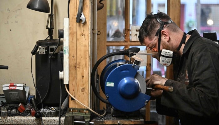 Ruari Black makes a bagpipe chanter in the workshop of Kilberry Bagpipes in Edinburgh, on October 7, 2024. —AFP