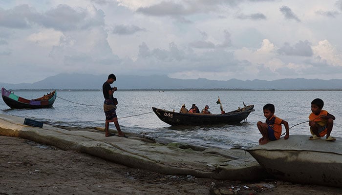 Maungdaw township of Myanmar is seen while Bangladeshi people spend leisure time in the afternoon at the bank of Naf river, near the Myanmar-Bangladesh border, during the ongoing conflict in the Rakhine state of Myanmar, in Coxs Bazar, Bangladesh on September 26, 2024. — Reuters