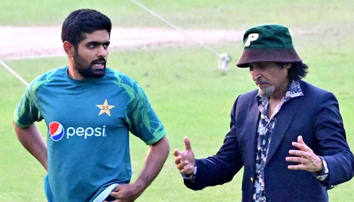 National cricketer Babar Azam (L) and Ramiz Raja captured during a discussion at a cricket ground. — AFP/File