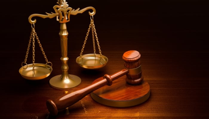 A representational image of scales of justice and a gavel.