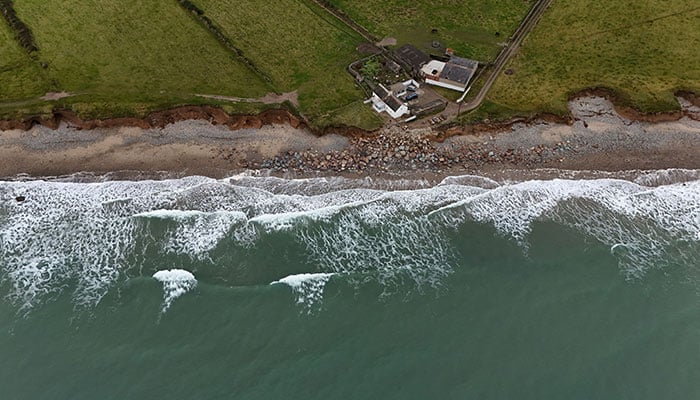 A drone view shows Lal and Willie Pierces 200-year-old ancestral family home which is at risk of being claimed by the sea due to coastal erosion hastened by climate change, in Ballyhealy, Ireland October 14, 2024. — Reuters