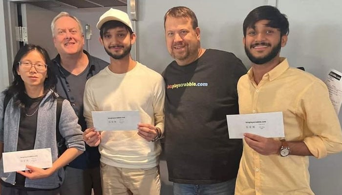 Pakistans Sohaib Sanaullah (right in yellow shirt) poses for a photo after winning the B Division of the Lake George Scrabble Tournament in New York. — Reporter