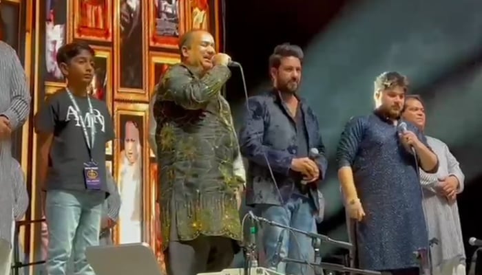 Ustad Rahat Fateh Ali Khan (centre with mic) and his son Shahzaman Ali Khan (right with mic) on stage at a concert in Dallas, Texas. — Reporter