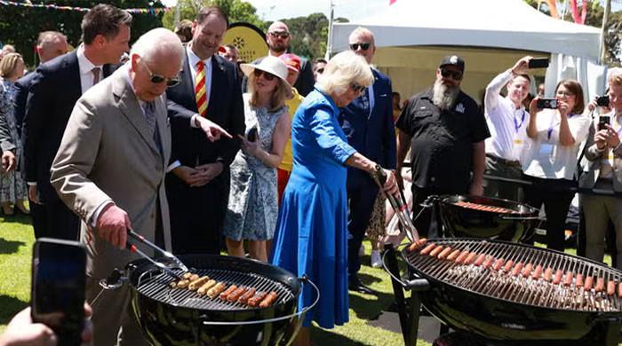 King Charles, Queen Camilla try their hands turning sausages