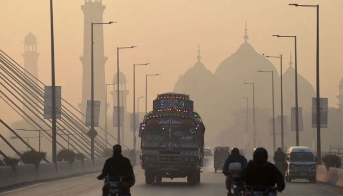 Vehicles make their way amid heavy smog conditions in Lahore, Pakistan, on November 17, 2021. — AFP