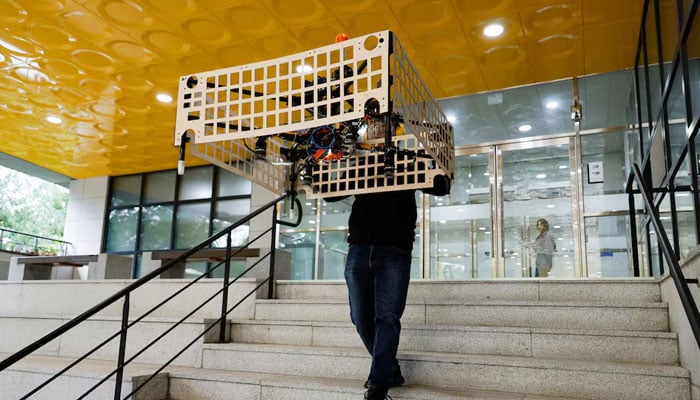 A graduate student of Mechanical Design and Robot Engineering at Seoul National University of Science and Technology, demonstrates the aerial transportation platform Palletrone on stairs at the Seoul Tech in Seoul, South Korea, on October 10, 2024. — Reuters