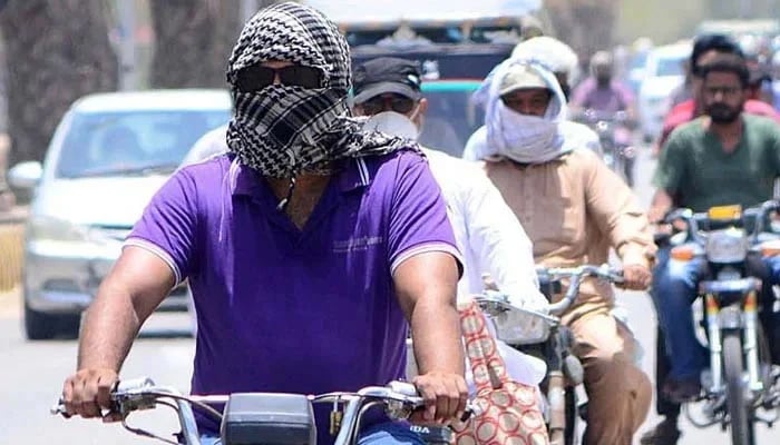 A motorcyclist on the way while covering their faces with cloth to protect from heatstroke during extreme heatwave. — APP/File