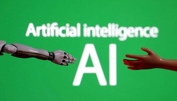 Words reading Artificial intelligence AI, miniature of robot and toy hand are pictured in this illustration taken December 14, 2023. — Reuters