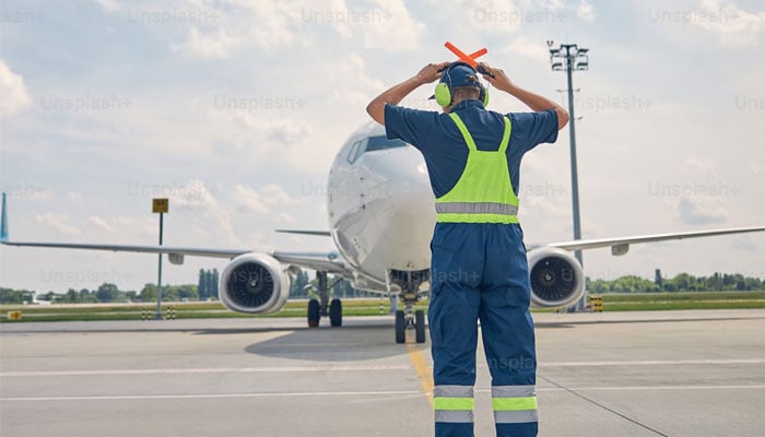 A representative image showing the pilot directing the plane onto the runway. — Unsplash