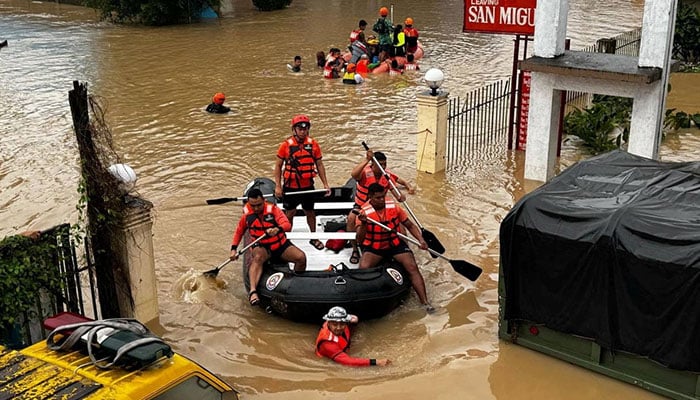 Philippine Coast Guard personnel evacuate residents after floodwaters rose due to heavy rains brought by Tropical Storm Trami in Camarines Sur, Philippines on October 24, 2024. – Reuters