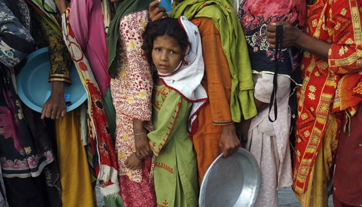 Flood victims stand in line to get food handouts while taking refuge with their family in a relief camp for flood victims in Sukkur, Sindh, on August 27, 2022. — Reuters