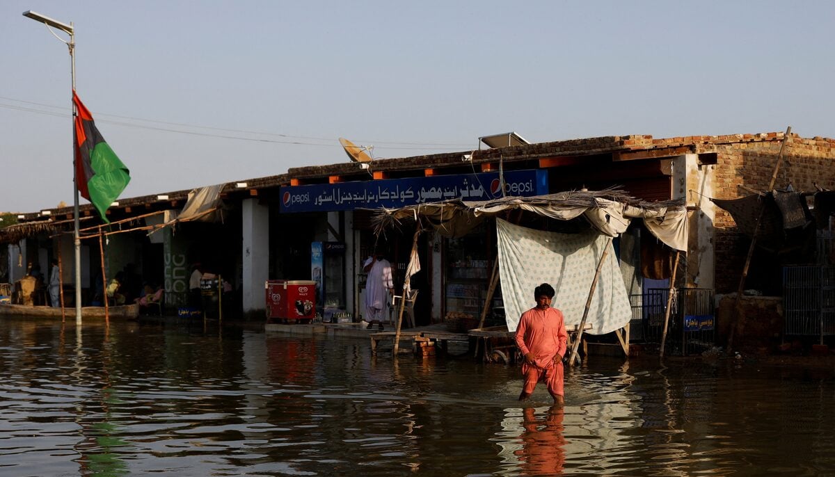 A man wades through flood water along a market, following rains and floods during the monsoon season in Bajara village, at the banks of Manchar lake, in Sindhs Sehwan district, on September 6, 2022. — Reuters