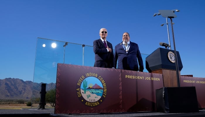 US President Joe Biden gestures to the audience as he stands with Stephen Roe Lewis, Governor of the Gila River Indian Community, at Gila Crossing Community School in Gila River Indian Community, Arizona, US, on October 25, 2024. —Reuters