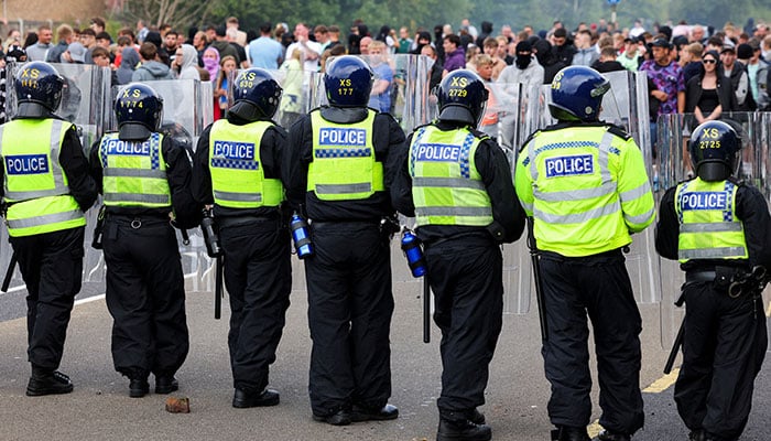 Police officers stand near a broken microphone during an anti-immigration protest, in Rotherham, Britain, August 4, 2024. — Reuters