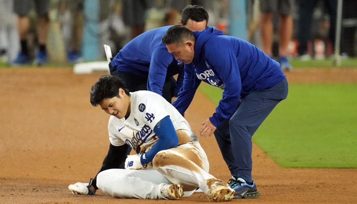 Los Angeles Dodgers Shohei Ohtani reacts at second base after an apparent injury in the seventh inning against the New York Yankees during game two of the 2024 MLB World Series at Dodger Stadium.