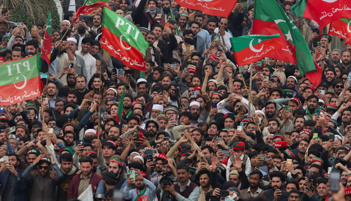 Supporters of PTI wave flags as they protest in Peshawar, on February 17, 2024. — Reuters