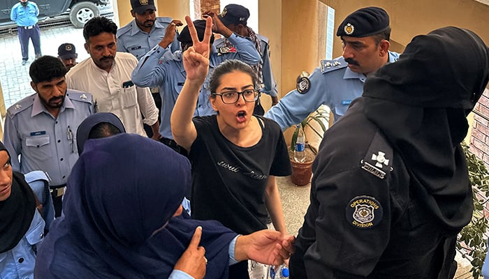 Police officials presents arrested lawyer and human rights activist Imaan Mazari-Hazir (centre) before a court in Islamabad on August 20, 2023. — AFP