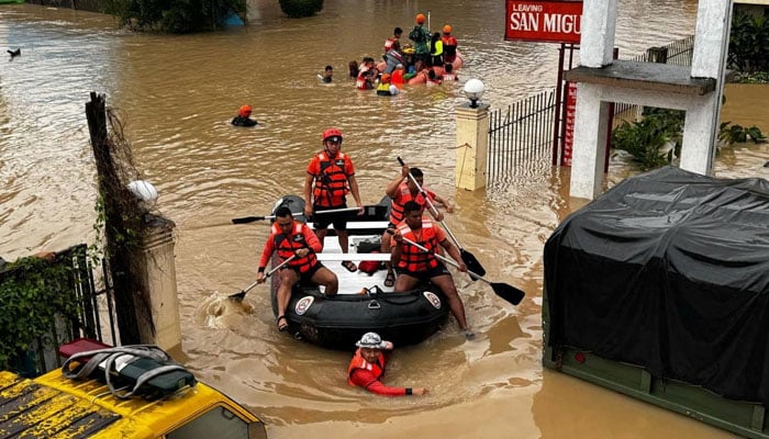 Philippine Coast Guard personnel evacuate residents after flood waters rose due to heavy rains brought by Tropical Storm Trami in Camarines Sur, Philippines on October 24, 2024. — Reuters