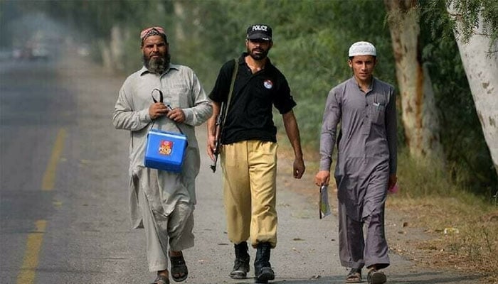 A file photo of polio workers in Khyber Pakhtunkhwa accompanied by a policeman. — Reuters