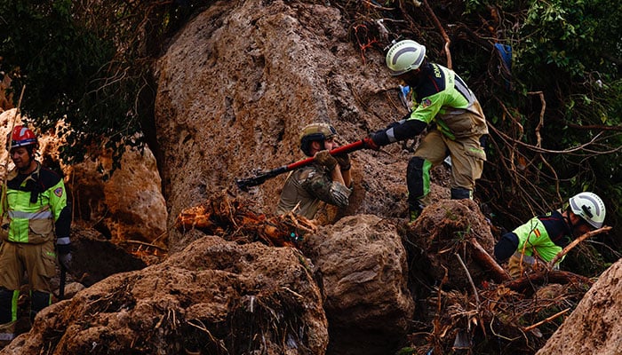 Members of a rescue team search for missing people near a river after heavy rains caused flooding in Letur, Spain, October 30, 2024. — Reuters