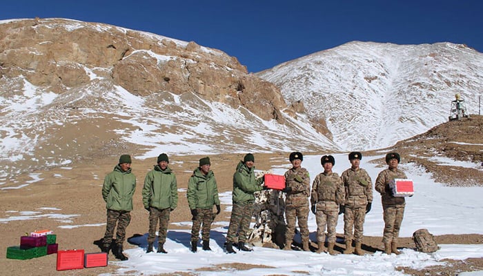 Indian and Chinese armies salute each other along the Line of Actual Control (LAC) near the Karakoram Pass in Ladakh on October 31, 2024, on the occasion of Diwali. - Agence France-Presse