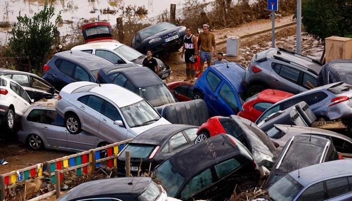 People stand next to stranded cars, following floods in Valencia, Spain, October 31, 2024. — Reuters