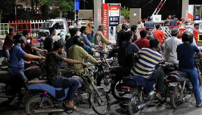 People wait for their turn to get fuel at a petrol station in Karachi, on July 4, 2024. — Reuters