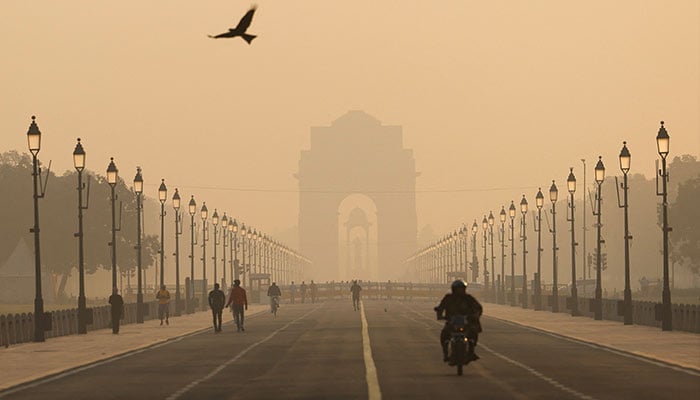 People walk on Kartavyapath near India Gate on a hazy morning in New Delhi, India, November 1, 2024. — AFP