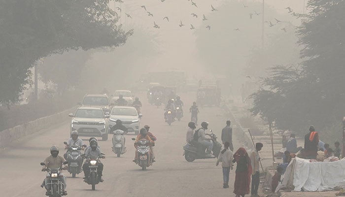 People and vehicles are seen on a road amidst the morning smog in New Delhi, India, November 8, 2023. — Reuters