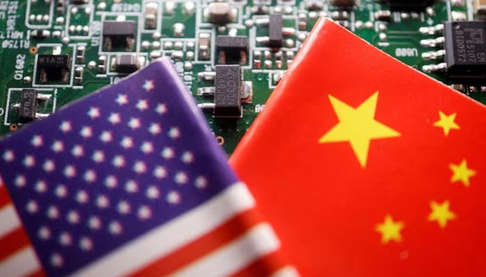 Flags of China and U.S. are displayed on a printed circuit board with semiconductor chips, in this illustration picture taken February 17, 2023. — Reuters